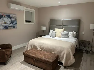 a bedroom with a large bed and a chair at Luxury accomodation in West Vancouver in West Vancouver