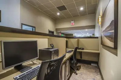 an office with a desk with a computer monitor and chairs at Quality Hotel & Conference Centre in Fort McMurray