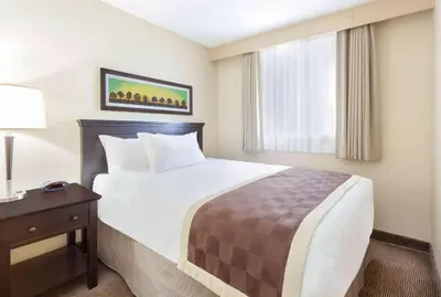 a hotel room with a bed and a window at Baymont by Wyndham Red Deer in Red Deer