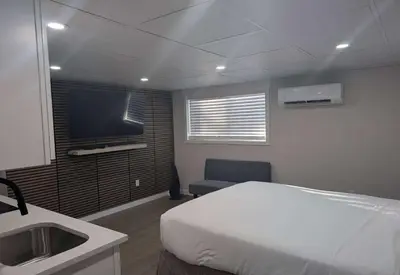 a bedroom with a bed and a tv and a sink at Baymont by Wyndham Red Deer in Red Deer