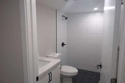 a white bathroom with a toilet and a sink at Baymont by Wyndham Red Deer in Red Deer