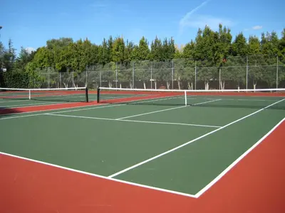 a person is standing on a tennis court at Baymont by Wyndham Red Deer in Red Deer