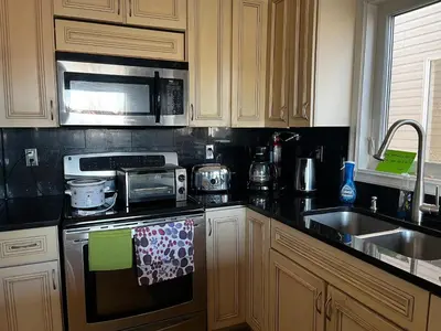 a kitchen with a stove top oven next to a sink at Citadel hill cr community! in Calgary