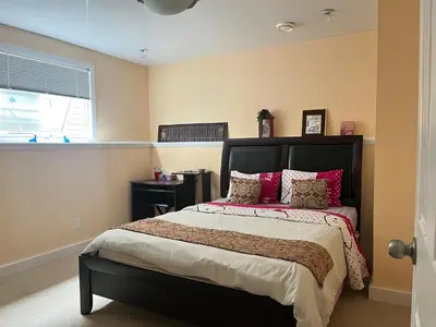 a bedroom with a large bed with red pillows at Citadel hill cr community! in Calgary