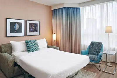 a hotel room with a bed and a chair at Residence Inn by Marriott Vancouver Downtown in Vancouver