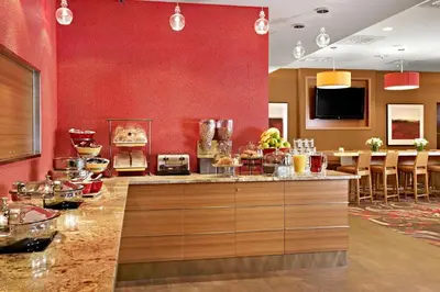 a restaurant with red walls and a counter with food at Residence Inn by Marriott Vancouver Downtown in Vancouver