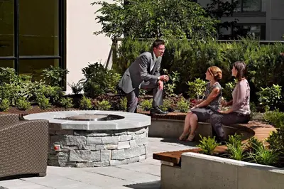 three people sitting on a bench in a garden at Residence Inn by Marriott Vancouver Downtown in Vancouver
