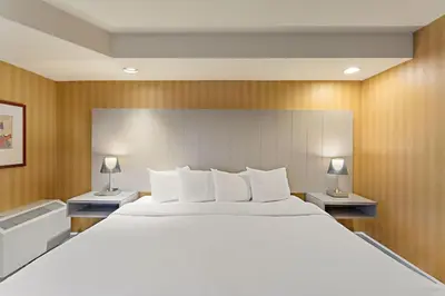 a large white bed in a room with two lamps at Executive Hotel Vancouver Airport in Richmond