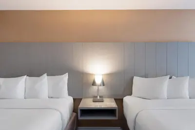a hotel room with two beds and a table with a lamp at Executive Hotel Vancouver Airport in Richmond