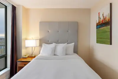 a white bed in a hotel room with a window at Executive Hotel Vancouver Airport in Richmond