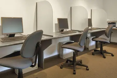 a row of desks with chairs and computers on them at Edmonton Inn and Conference Centre in Edmonton