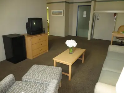 a living room with a couch and a table with flowers at Edmonton Inn and Conference Centre in Edmonton