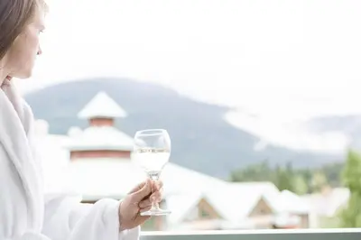 a woman holding a glass of white wine at Summit Lodge Boutique Hotel by Paradox in Whistler