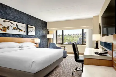 a hotel room with a bed and a desk with a computer at Delta Hotels by Marriott Calgary Downtown in Calgary