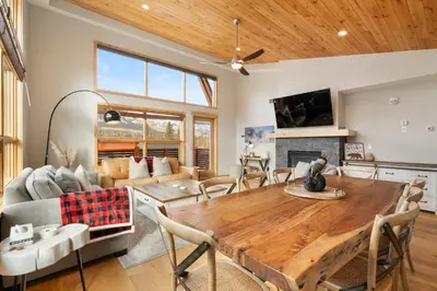 a living room with a wooden table and a fireplace at Spring Creek Penthouse by Canadian Rockies Vacation Rentals in Canmore
