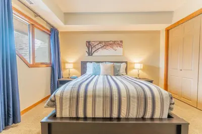 a bedroom with a bed and two lamps on two tables at Cascade Penthouse by Canadian Rockies Vacation Rentals in Canmore