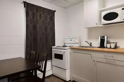 a small kitchen with a table and a microwave at Howard Johnson by Wyndham Grande Prairie in Grande Prairie