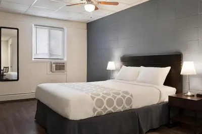 a bedroom with a large bed and a ceiling fan at Howard Johnson by Wyndham Grande Prairie in Grande Prairie