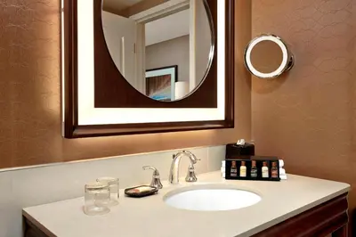 a bathroom with a sink and a mirror at Sheraton Suites Calgary Eau Claire in Calgary