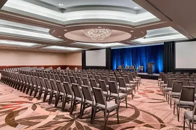 a room with rows of chairs in a room with a stage at Sheraton Suites Calgary Eau Claire in Calgary