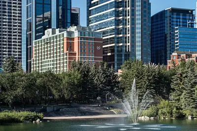 a fountain in a park in a city with tall buildings at Sheraton Suites Calgary Eau Claire in Calgary