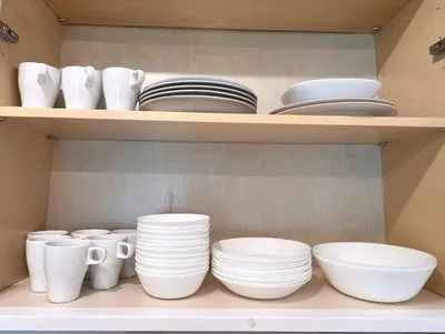 a shelf with white plates and bowls and plates at Victory House in Burnaby