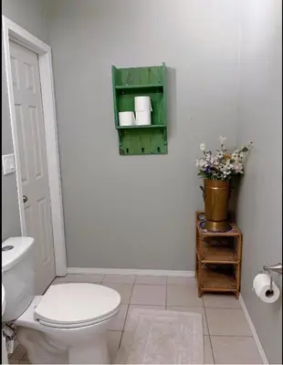 a bathroom with a toilet and a vase of flowers at Banff -Calgary Garden &3 mins Bus station Close C-Train&Free Parking in Calgary