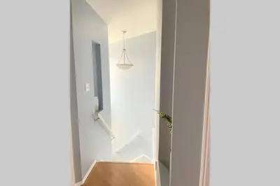a staircase in a house with a white wall at Spacious Duplex in Camrose