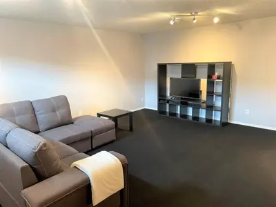 a living room with a couch and a flat screen tv at Spacious Duplex in Camrose