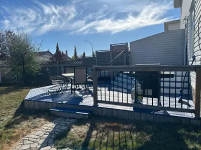 a deck with a table and chairs on it at Spacious Duplex in Camrose