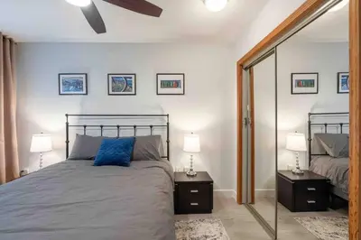 a bedroom with a bed and two lamps and a mirror at Updated Townhouse in Village. Pool/Hot Tub/Parking in Whistler