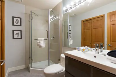 a bathroom with a shower and a toilet and a sink at Updated Townhouse in Village. Pool/Hot Tub/Parking in Whistler