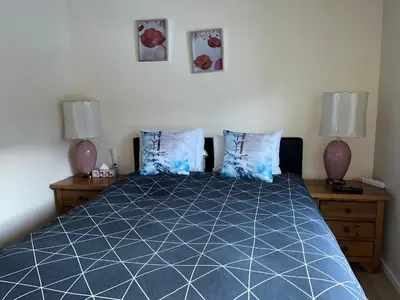 a bedroom with a blue bed with two lamps at Banff Gate vacation townhouse in Canmore