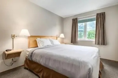 a bedroom with a large bed and a window at Banff Gate vacation townhouse in Canmore