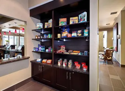 a restaurant with a shelf with food on it at Homewood Suites Calgary Airport in Calgary