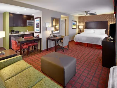 a large hotel room with a bed and a kitchen at Homewood Suites Calgary Airport in Calgary