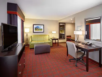 a hotel room with a desk and a living room at Homewood Suites Calgary Airport in Calgary