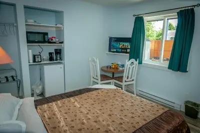 a bedroom with a bed and a table and a window at Guest Suite Private Retreat for 2 Guests With AC - 4 Units Available in Abbotsford