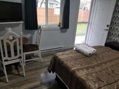 a bedroom with a bed and a chair and a window at Guest Suite Private Retreat for 2 Guests With AC - 4 Units Available in Abbotsford