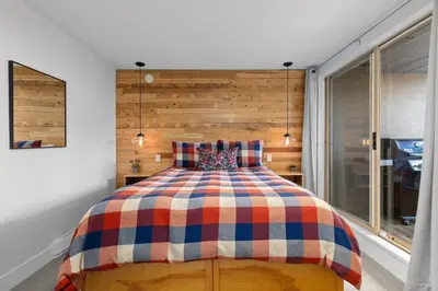 a bedroom with a large bed with a wooden headboard at 2BR in Gleneagle, Gourmet Kitchen, Newly Updated, Wood Burning Fireplace, Parking in Whistler