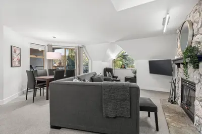 a living room with a couch and a dining room at 2BR in Gleneagle, Gourmet Kitchen, Newly Updated, Wood Burning Fireplace, Parking in Whistler