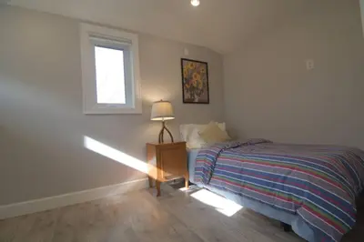 a bedroom with a bed and a window at Vancouver Traveller Cottage in Vancouver