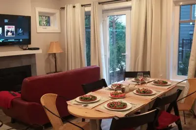 a dining room with a table and a red couch at Vancouver Traveller Cottage in Vancouver