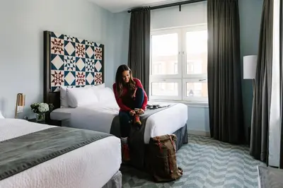 a woman sitting on a bed in a hotel room at Mount Royal Hotel in Banff