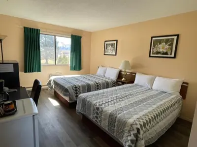 a hotel room with two beds and a desk at Y-5 Motel in Barrière