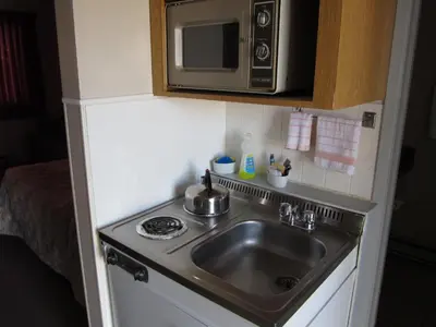 a kitchen with a sink and a microwave at Y-5 Motel in Barrière