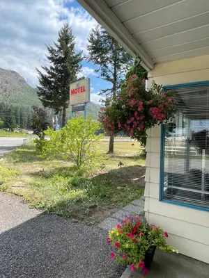 a motel sign and flowers on the side of a building at Y-5 Motel in Barrière