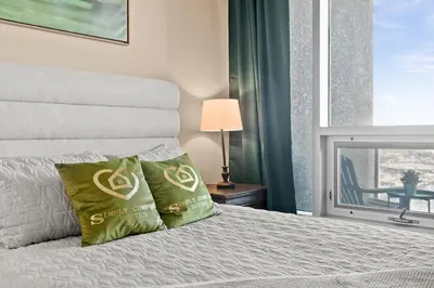a bedroom with a bed and a window with a table at GlobalStay Downtown Calgary Condos in Calgary