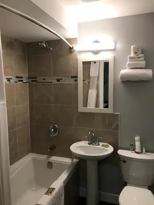 a bathroom with a sink and a toilet and a tub at 94 Motel & RV Park in One Hundred Mile House