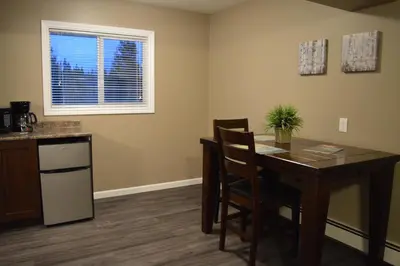 a kitchen with a dining room table and a window at 94 Motel & RV Park in One Hundred Mile House